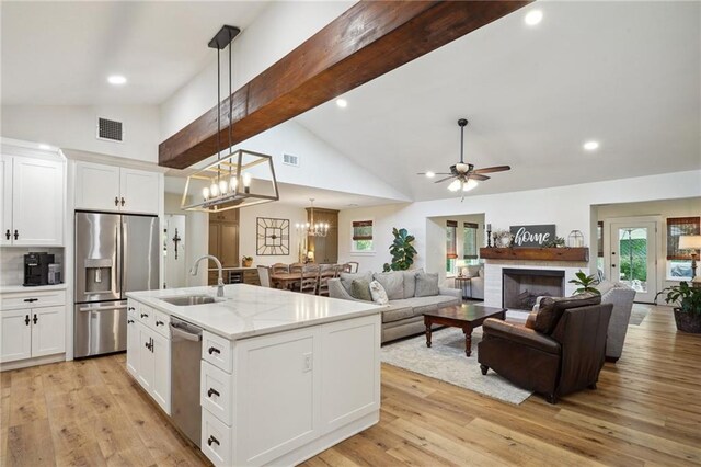133 Crapemyrtle Rd, Covington, LA 70433 - kitchen featuring appliances with stainless steel finishes, a ceiling fan, white cabinets, decorative light fixtures, and light wood-type flooring