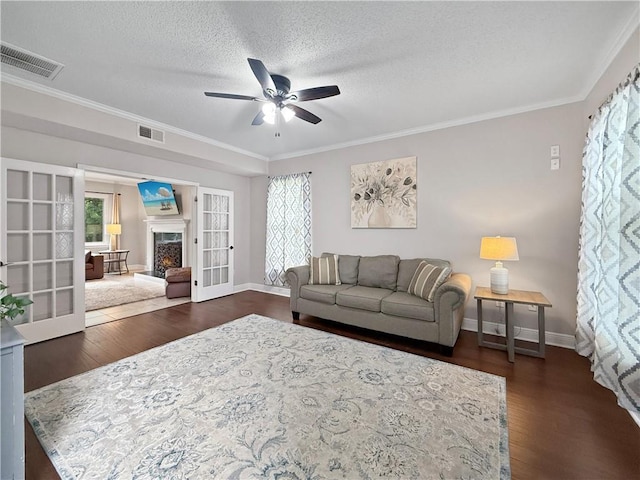2009 Rubich Ln, Slidell, LA 70461 - living area featuring ceiling fan, plenty of natural light, dark wood-type flooring, ornamental molding, and a textured ceiling