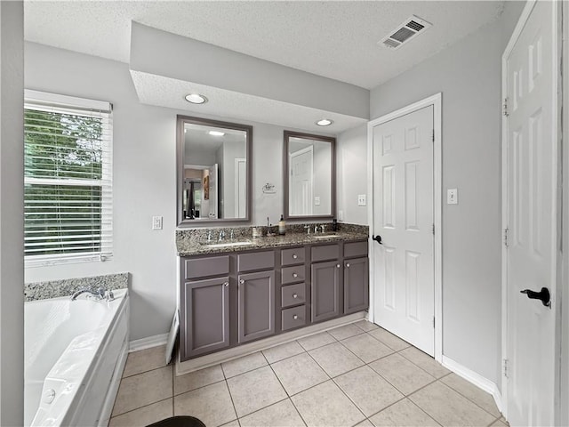 2009 Rubich Ln, Slidell, LA 70461 - bathroom featuring double vanity, a textured ceiling, a garden tub, tile patterned floors, and recessed lighting