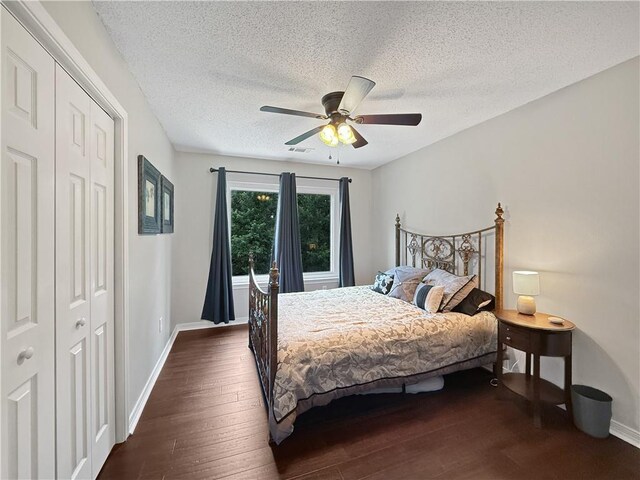 2009 Rubich Ln, Slidell, LA 70461 - bedroom featuring dark wood-type flooring, a closet, a textured ceiling, and a ceiling fan
