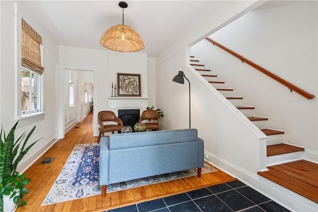 1016 Constantinople St, New Orleans, LA 70115 - living area with stairway, a fireplace, and wood finished floors