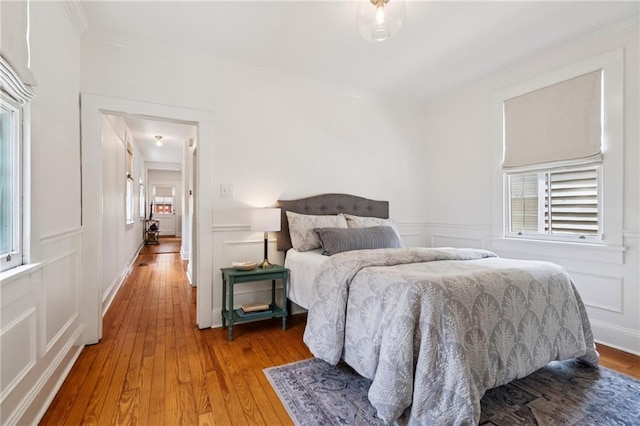 1016 Constantinople St, New Orleans, LA 70115 - bedroom with a decorative wall, ornamental molding, hardwood / wood-style floors, and a wainscoted wall
