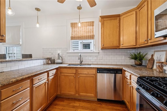 1016 Constantinople St, New Orleans, LA 70115 - kitchen featuring dishwasher, backsplash, wood finished floors, a ceiling fan, and pendant lighting