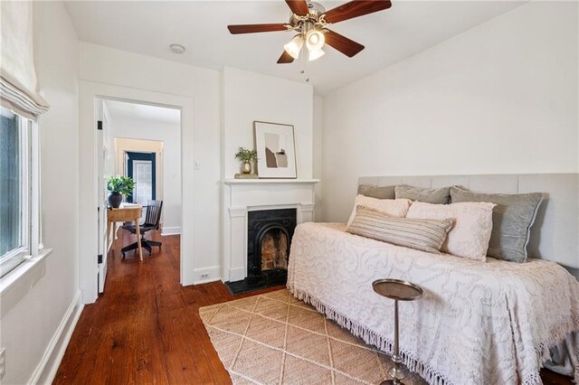 1016 Constantinople St, New Orleans, LA 70115 - bedroom with wood finished floors, a fireplace with flush hearth, and a ceiling fan