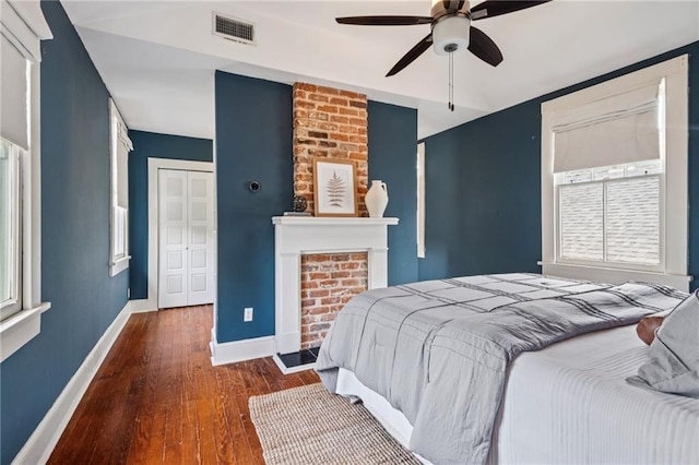 1016 Constantinople St, New Orleans, LA 70115 - bedroom with hardwood / wood-style flooring, a fireplace, a ceiling fan, and a closet