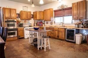 78028 N Fitzmorris Ext, Covington, LA 70435 - kitchen with beverage cooler, double oven, brown cabinets, and a breakfast bar