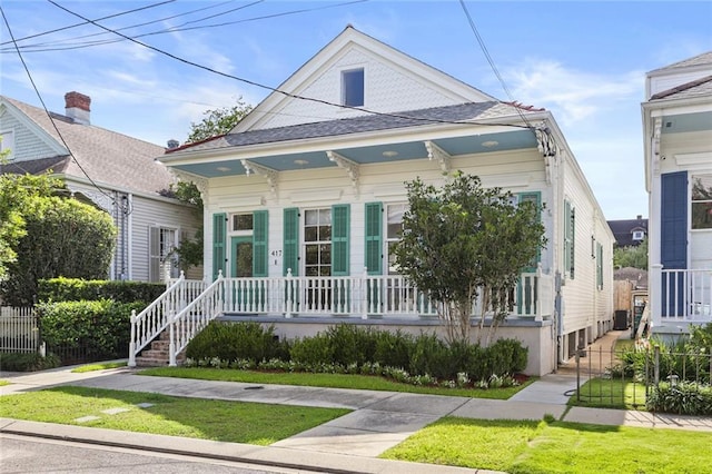 417 Eleonore St, New Orleans, LA 70115 - shotgun-style home featuring covered porch and a shingled roof