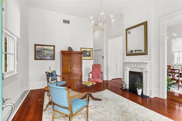 417 Eleonore St, New Orleans, LA 70115 - living area featuring wood finished floors, a chandelier, ornamental molding, and a fireplace