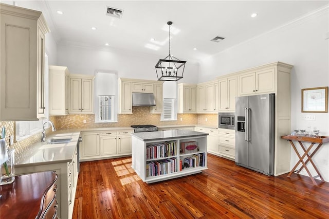 417 Eleonore St, New Orleans, LA 70115 - kitchen with appliances with stainless steel finishes, under cabinet range hood, cream cabinetry, a chandelier, and open shelves