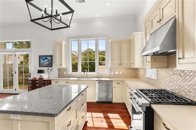 417 Eleonore St, New Orleans, LA 70115 - kitchen featuring cream cabinets, stainless steel appliances, under cabinet range hood, dark wood-style flooring, and recessed lighting