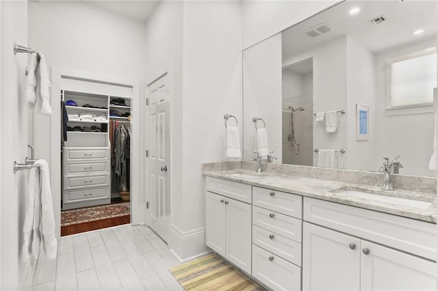 417 Eleonore St, New Orleans, LA 70115 - full bathroom with a shower stall, double vanity, a walk in closet, and recessed lighting