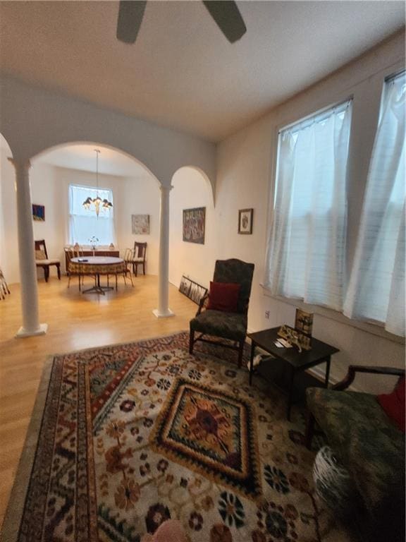 2715 Marengo St, New Orleans, LA 70115 - sitting room with decorative columns, arched walkways, wood finished floors, and a ceiling fan