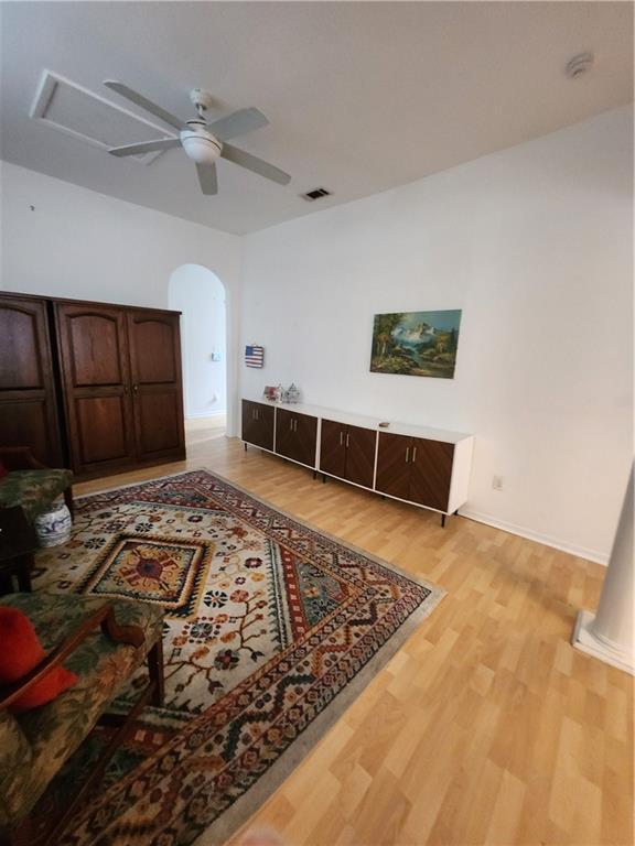 2715 Marengo St, New Orleans, LA 70115 - living room with light wood-type flooring, ceiling fan, and arched walkways