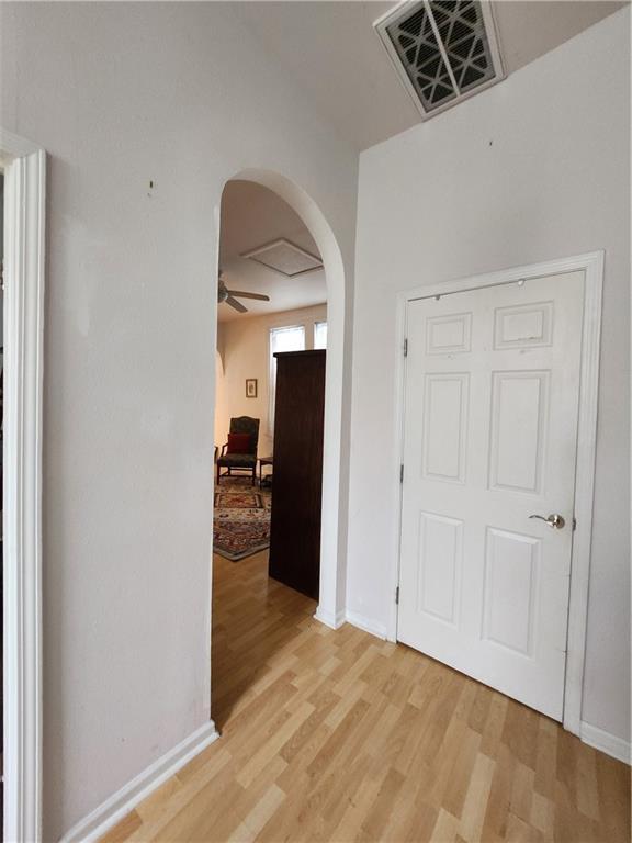 2715 Marengo St, New Orleans, LA 70115 - hallway with arched walkways and light wood-style flooring