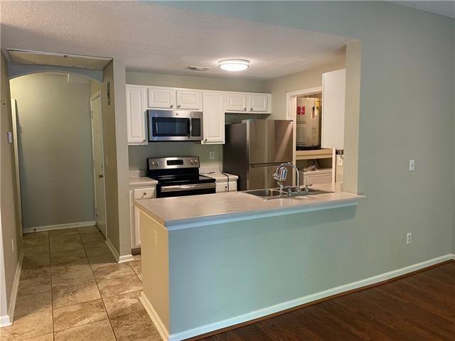 350 Emerald Forest Ave Unit 5202, Covington, LA 70433 - kitchen with appliances with stainless steel finishes, a peninsula, white cabinetry, light countertops, and arched walkways