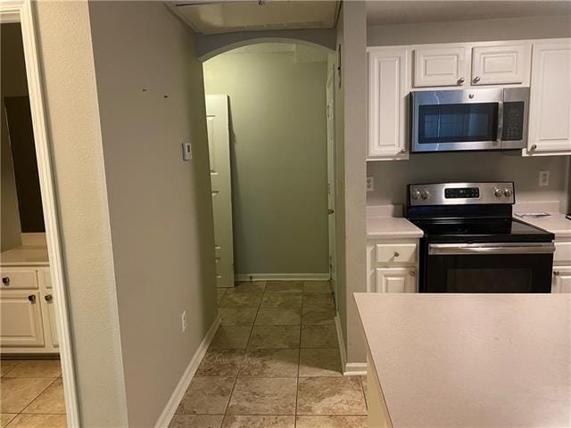 350 Emerald Forest Ave Unit 5202, Covington, LA 70433 - kitchen with stainless steel appliances, arched walkways, white cabinets, light countertops, and light tile patterned flooring