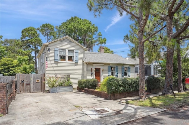 223840 Dante St, New Orleans, LA 70118 - tri-level home with a chimney, concrete driveway, and a gate