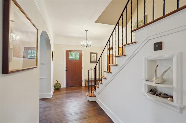 223840 Dante St, New Orleans, LA 70118 - foyer with arched walkways, a chandelier, stairs, and wood finished floors