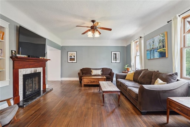 223840 Dante St, New Orleans, LA 70118 - living room featuring a ceiling fan, a textured ceiling, wood-type flooring, and a fireplace with raised hearth