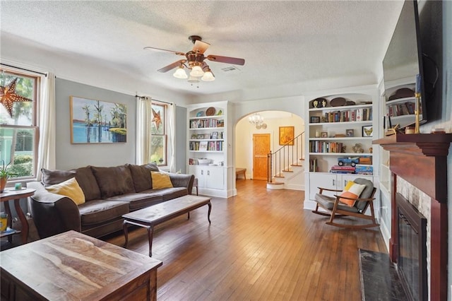 223840 Dante St, New Orleans, LA 70118 - living area with a textured ceiling, arched walkways, ceiling fan, a tile fireplace, and built in features