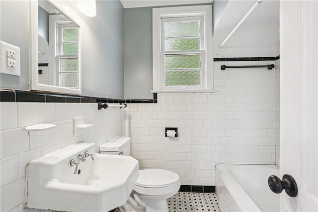 223840 Dante St, New Orleans, LA 70118 - bathroom with tile walls, a tub, a wainscoted wall, and tile patterned floors