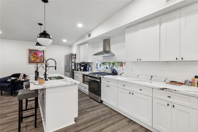 6709 Hastings St, Metairie, LA 70003 - kitchen with appliances with stainless steel finishes, range hood, lofted ceiling, white cabinetry, and wood finished floors