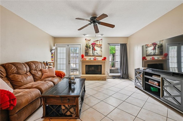 181 Sandra Del Mar Dr Unit 181, Mandeville, LA 70448 - living area with a brick fireplace, ceiling fan, a textured ceiling, and light tile patterned floors