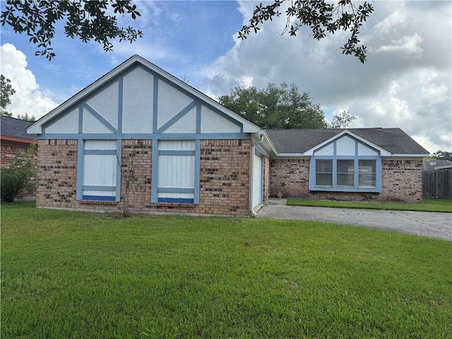 204 Portsmouth Dr, Slidell, LA 70460 - tudor house featuring an attached garage, brick siding, a front lawn, and driveway