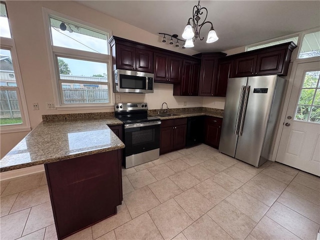 6 Brentwood Dr, Metairie, LA 70003 - kitchen featuring appliances with stainless steel finishes, a peninsula, a chandelier, stone countertops, and decorative light fixtures