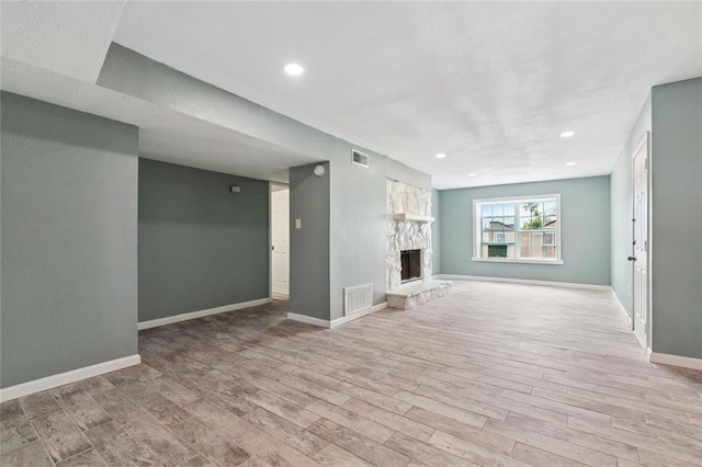 6200 Riverside Dr Unit 625, Metairie, LA 70003 - unfurnished living room featuring wood finished floors, a stone fireplace, and recessed lighting