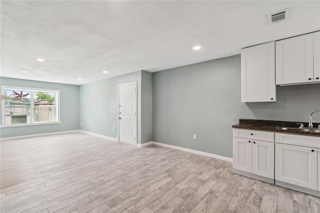 6200 Riverside Dr Unit 625, Metairie, LA 70003 - kitchen featuring light wood-style flooring, open floor plan, white cabinets, and recessed lighting