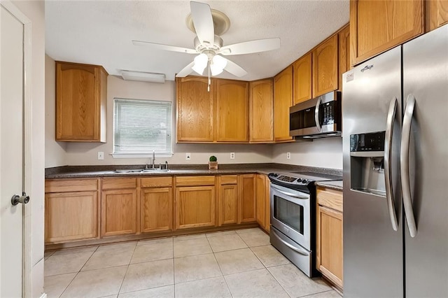 761 Holyoke Pl, Terrytown, LA 70056 - kitchen with appliances with stainless steel finishes, dark countertops, light tile patterned floors, and brown cabinetry