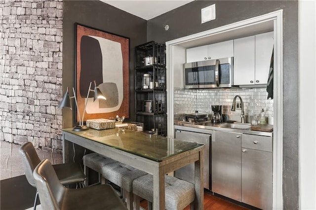 1205 St Charles Ave Unit 704, New Orleans, LA 70130 - bar area featuring stainless steel appliances, tasteful backsplash, and dark wood finished floors