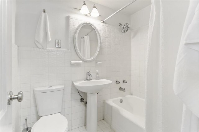 1205 St Charles Ave Unit 704, New Orleans, LA 70130 - bathroom featuring shower / bath combo with shower curtain and tile walls