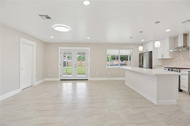 14 Derbes Dr, Gretna, LA 70053 - kitchen with wall chimney range hood, appliances with stainless steel finishes, white cabinets, light countertops, and decorative backsplash