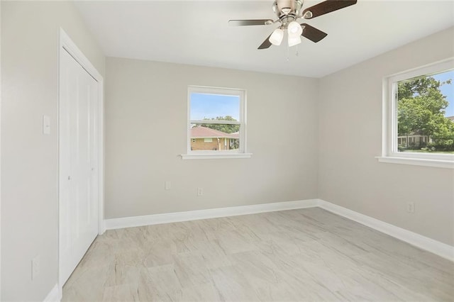 14 Derbes Dr, Gretna, LA 70053 - unfurnished bedroom featuring multiple windows, a closet, light marble finish flooring, and a ceiling fan