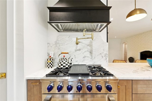 1528 N Cumberland St, Metairie, LA 70003 - kitchen featuring ventilation hood, stainless steel stove, backsplash, light stone countertops, and arched walkways