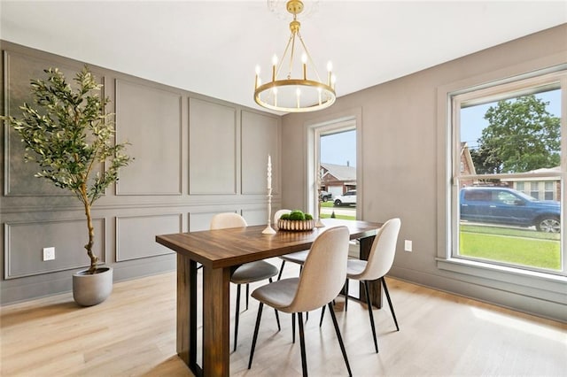 1528 N Cumberland St, Metairie, LA 70003 - dining area with a decorative wall, a chandelier, light wood finished floors, and plenty of natural light
