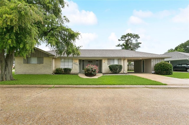4700 Jasper St, Metairie, LA 70006 - ranch-style house featuring concrete driveway, brick siding, a front lawn, a carport, and board and batten siding