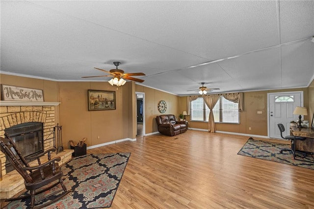 24483 Riley Rd, Pride, LA 70770 - living room featuring ceiling fan, light wood finished floors, ornamental molding, a fireplace, and a textured ceiling