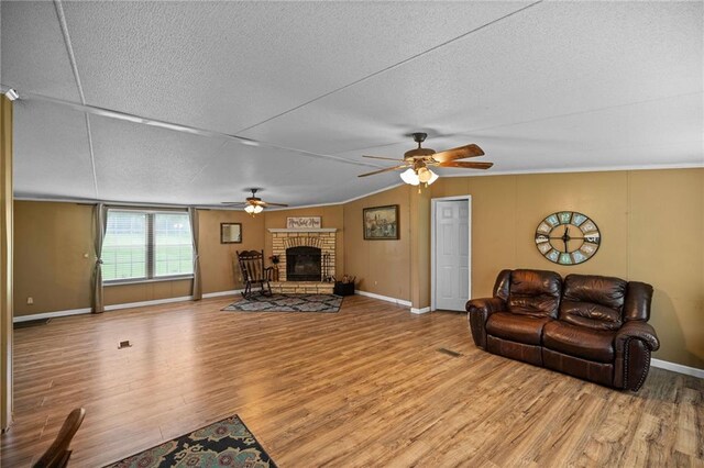 24483 Riley Rd, Pride, LA 70770 - living room featuring a ceiling fan, a brick fireplace, wood finished floors, and a textured ceiling