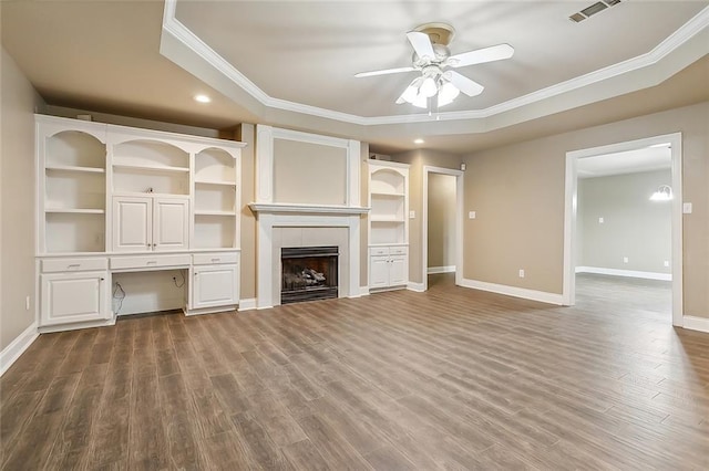 1410 Pecan St, Hammond, LA 70401 - unfurnished living room featuring a ceiling fan, ornamental molding, dark wood-type flooring, a tile fireplace, and built in desk