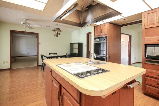 4808 Janice Ave, Kenner, LA 70065 - kitchen with white electric cooktop, custom exhaust hood, a ceiling fan, and light wood-style flooring
