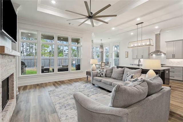 1161 Delta Ln, Covington, LA 70433 - living area featuring a fireplace, ornamental molding, ceiling fan, a chandelier, and recessed lighting
