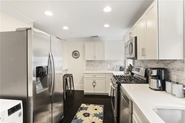 1028 Kerlerec St Unit 3, New Orleans, LA 70116 - kitchen with appliances with stainless steel finishes, light countertops, white cabinetry, recessed lighting, and ornamental molding