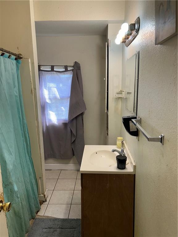 5423 Mandeville St, New Orleans, LA 70122 - bathroom with tile patterned floors, vanity, and a shower with shower curtain