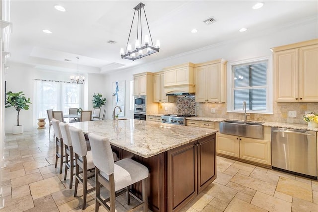 10 Finch St, New Orleans, LA 70124 - kitchen featuring appliances with stainless steel finishes, cream cabinetry, a chandelier, stone tile floors, and recessed lighting