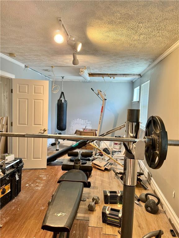 4925 Jasper St, Metairie, LA 70006 - workout room featuring crown molding, wood finished floors, and a textured ceiling
