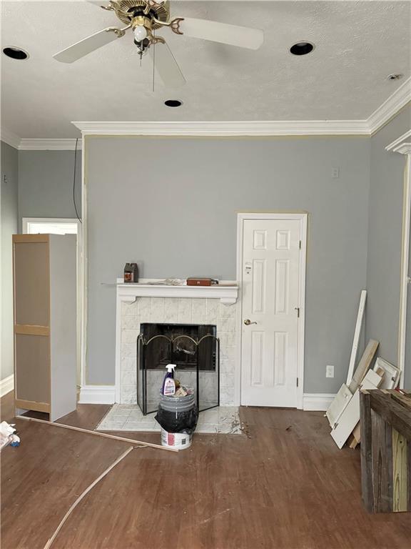 4925 Jasper St, Metairie, LA 70006 - living area with a tile fireplace, crown molding, wood finished floors, and ceiling fan