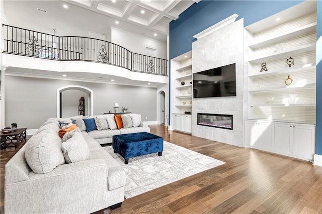 31350 Walker Rd, Walker, LA 70785 - living room featuring arched walkways, a towering ceiling, recessed lighting, a glass covered fireplace, and beam ceiling